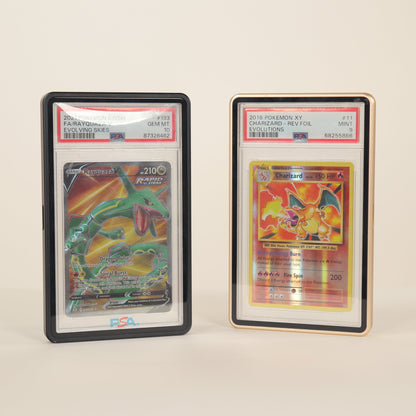 Two trading cards in protective cases on a beige background